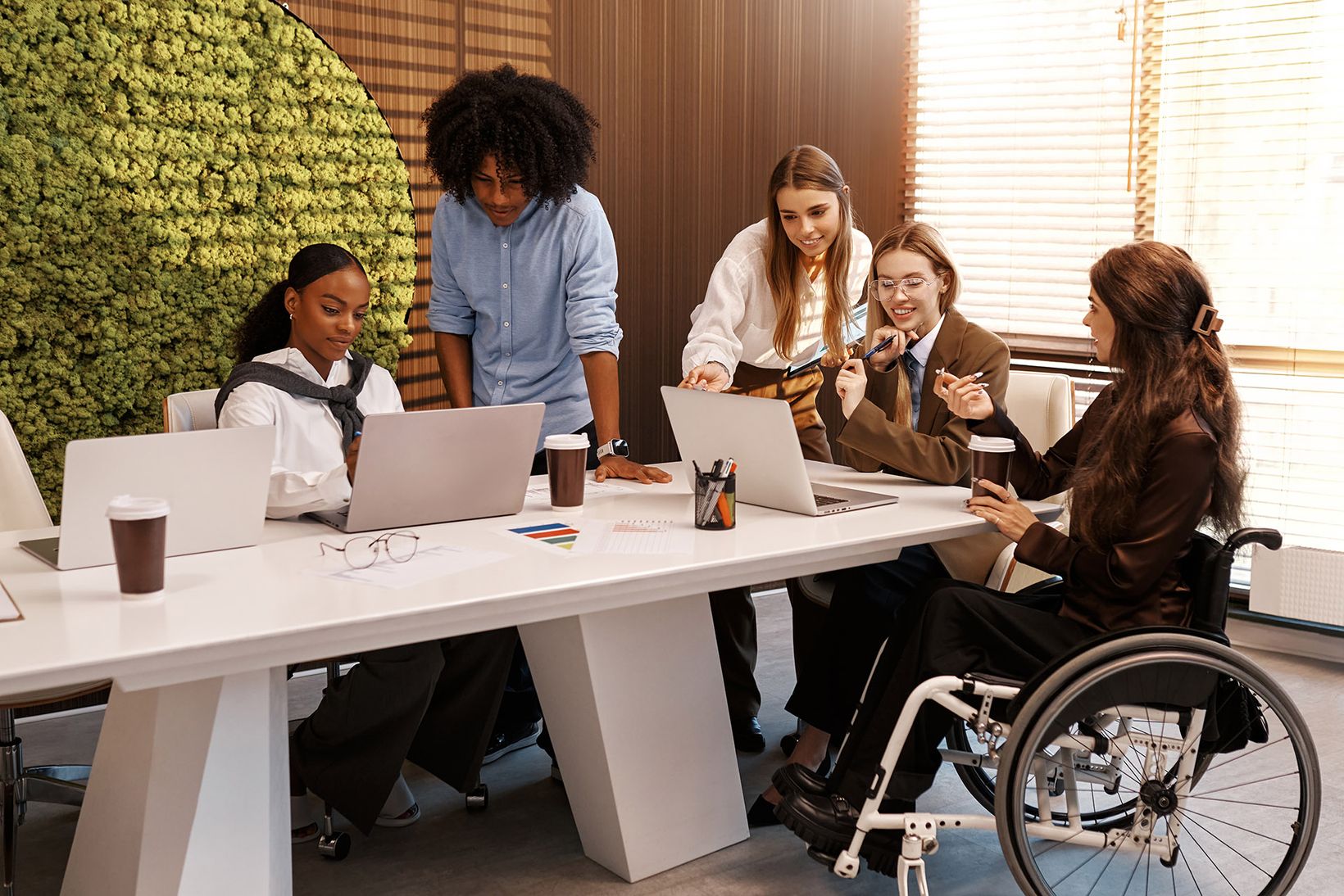 Group of people working at a table with a woman in a wheelchair